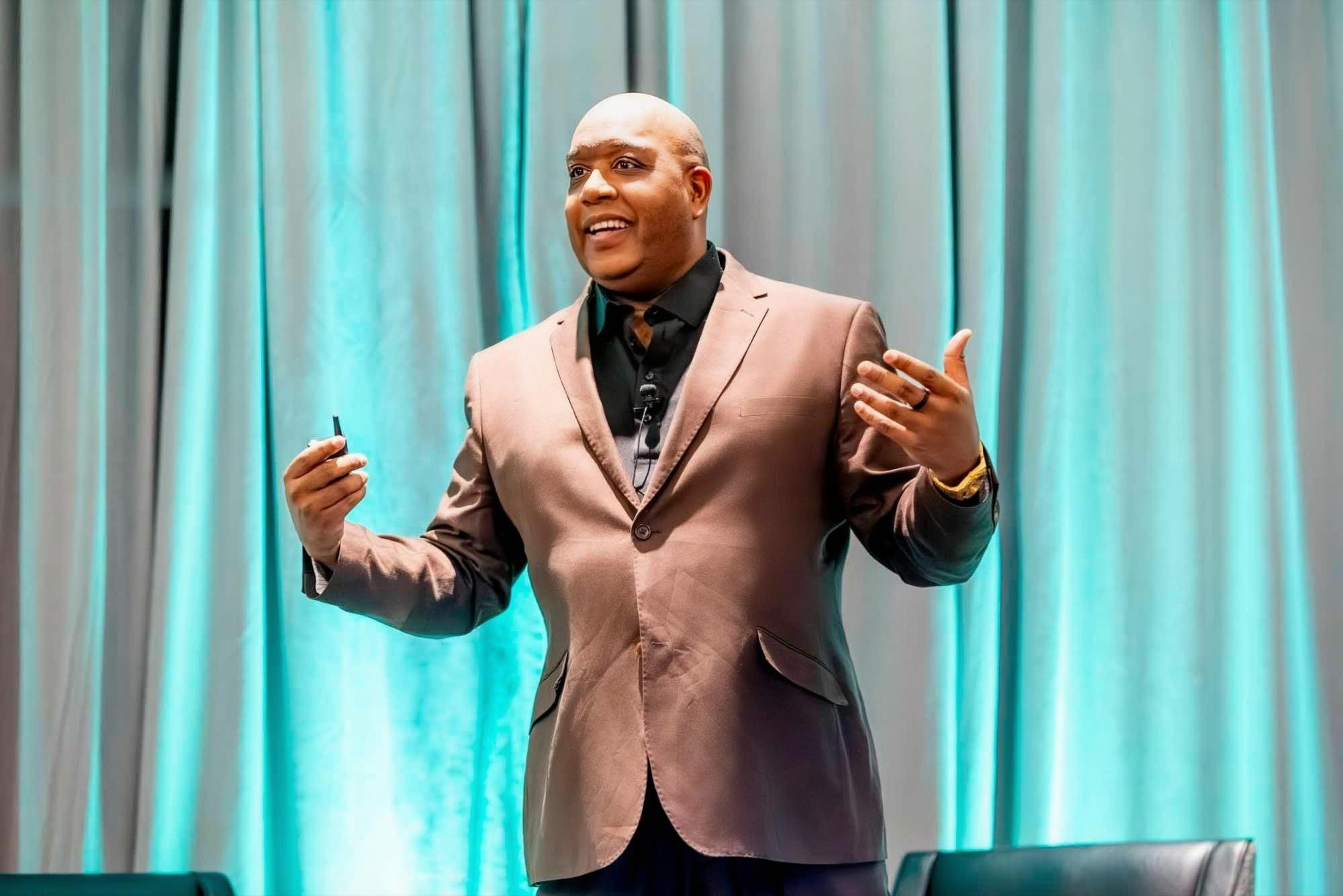 Omar L. Harris speaking on stage at a leadership event